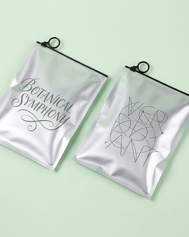 Custom silver slider zipper pouches with ring pull, elegant printed logo packaging bags on light green background